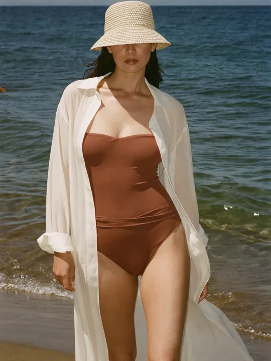 Instagram post: terracotta swimsuit and straw hat by the sea